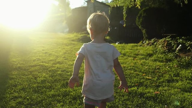 Little Girl Running On Grass At Sunset Slow Motion