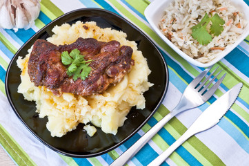 Roasted pork neck with potatoes decorated with coriander leaf
