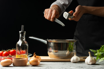 Preparation of tomato sauce by the hands of the chef, steps the process in the kitchen on a black background copy the text of the recipe.The concept of cooking food