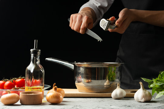 Preparation of tomato sauce by the hands of the chef, steps the process in the kitchen on a black background copy the text of the recipe.The concept of cooking food