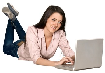 Friendly Young Woman Lying Down and Typing on a Laptop -