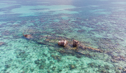 Naklejka na ściany i meble Half Submerged Shipwreck on Coral Reef