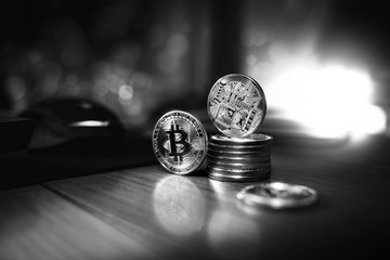 Bitcoin money lies on the wooden table and shine like a diamond in the darkness. 