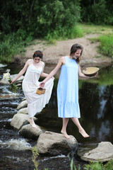 Beautiful girls in dresses on the river