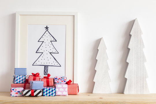 Christmas tree doodle in photo frame with stack of gifts.