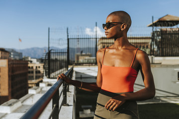 Young woman wearing sunglasses standing on rooftop