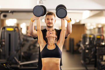 girl with fitness coach lifting weights