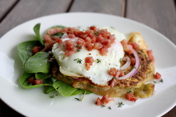 Zucchini and Sweet Potato Fritters with fried egg, bacon and salad, gourmet