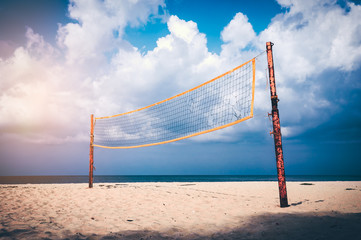 Volleyball court on an empty beach with blue cloudy sky.