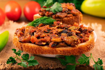Vegetable ragout of eggplant, zucchini, tomatoes and carrots on white bread with parsley and dill.
