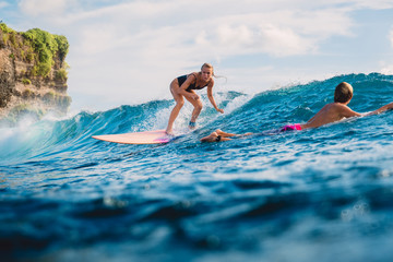 Surf girl on surfboard. Woman in ocean during surfing.