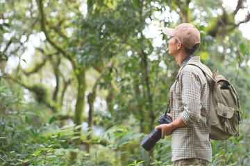 Thoughtful young man using camera while hiking in nature, Hiking and leisure ideas.