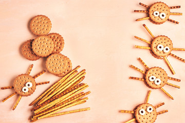 Group of double Halloween spider cookies on pink wooden background