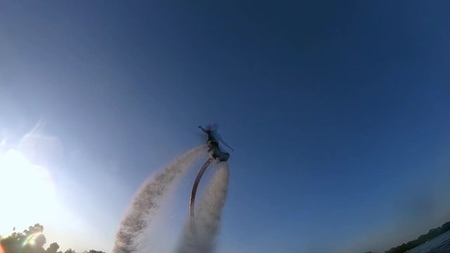 Flyboarder doing tricks slow motion flying Flyboarding wide shot view from bottom video