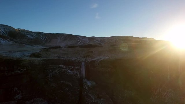 Ultra wide static aerial shot of Icelandic Waterfall Wide aerial shot flying towards and over Icelandic Waterfall Glj&radic;&int;frab&radic;&int;i with huge lens flare from setting sun