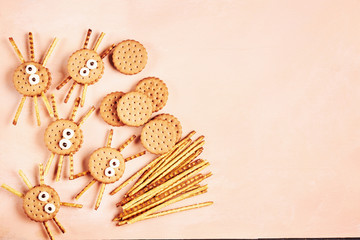 Group of double Halloween spider cookies on pink wooden background