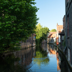Beautiful houses along calm canal in Bruges, Belgium.