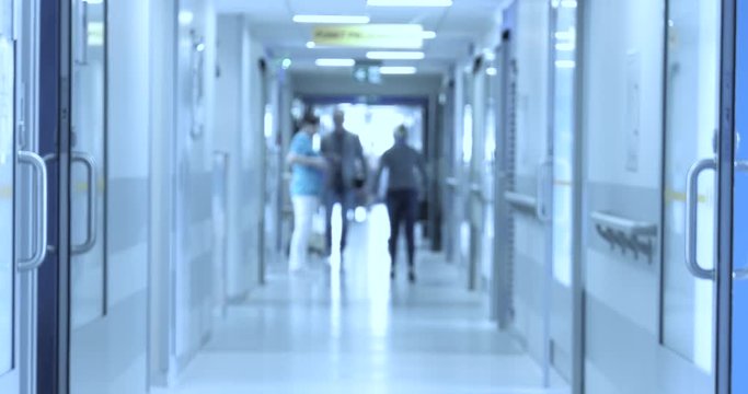 Doctors, nurses, patients and other employees walk around the hospital ward. Blur, Unfocus.
