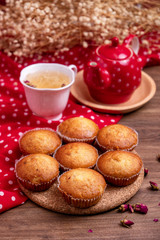 banana cup cake with a cup of tea and red tea pot on wooden table