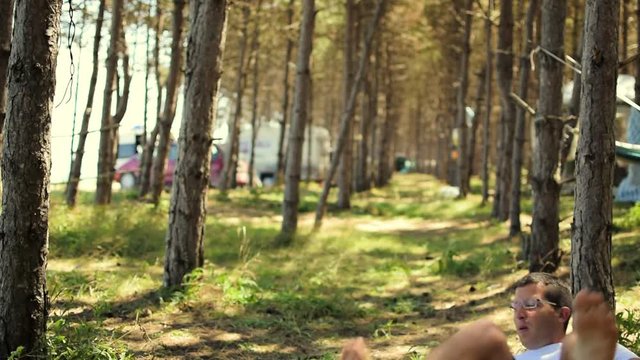 Man falling out of a hammock in the forest on a summer day
