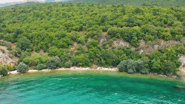 Aerial (drone) truck shot from left to right of Macedonian shore in Ohrid Lake, Pesztani and Trpejca