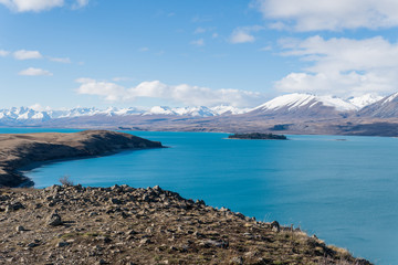 Fototapeta na wymiar bay and mountains at Lake Tekapo while hiking the trail with island in view