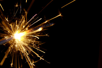 Fototapeta premium Firework background / A sparkler is a type of hand-held firework that burns slowly while emitting colored flames, sparks, and other effects