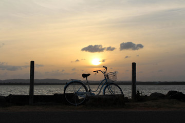 Fototapeta premium A bicycle and sunset around Bendiwewa Lake in Polonnaruwa