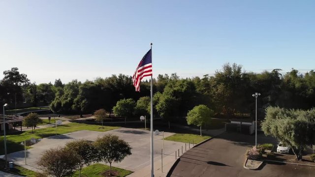 Beautiful aerial drone shot of a suburban Park in Clovis California with a United States Flag.