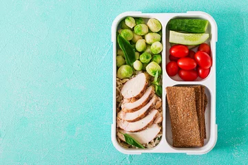 Fotobehang Healthy green meal prep containers with chicken fillet, rice, brussels sprouts and vegetables overhead shot with copy space. Dinner in lunch box. Top view. Flat lay © timolina