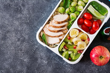 Healthy green meal prep containers with chicken fillet, rice, brussels sprouts, vegetables and...