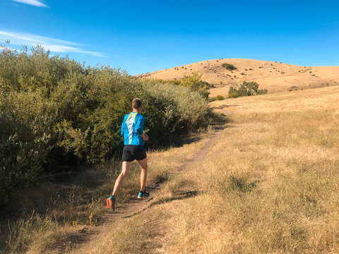 Man on a trail run in foothills