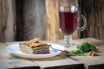 red tea and baklava with walnuts and mint on wooden background