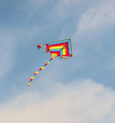 colorful kite flies high in the blue sky