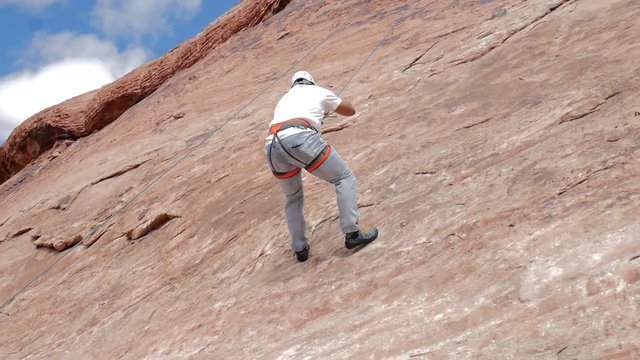 Beginner rock climber descends from his first climb.
