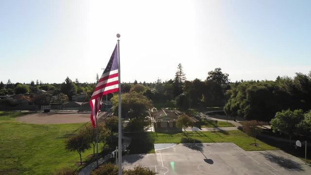 Beautiful aerial drone shot of a suburban Park in Clovis California with a United States Flag.