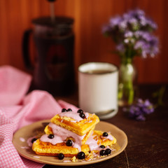 Fresh homemade Viennese waffles, drenched with yogurt and berries