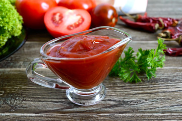 Tomato sauce with garlic, spices, herbs on the wooden table. Ketchup.