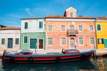 Fototapeta na wymiar Colorful buildings and boat on canal in Burano island, Venice, Italy