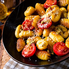 gnocchi baked with green pesto, cherry tomatoes and parmesan