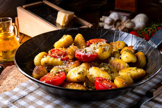 gnocchi baked with green pesto, cherry tomatoes and parmesan