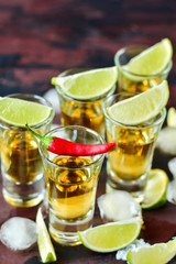 Red chili on a glass of alcohol, five glasses of alcohol and lime, a party at the bar, a menu for the bar. Selective focus and copy space
