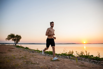 Athletic young man running in the nature. Healthy lifestyle