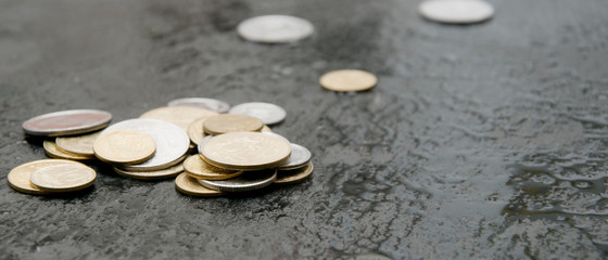 Coins on a black wet surface.