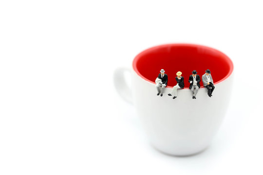 Miniature people : People sitting on cup using for concept of Native American Day.