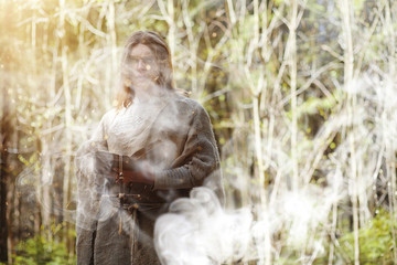 A man in a cassock spends a ritual in a dark forest