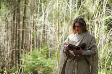 A man in a cassock spends a ritual in a dark forest