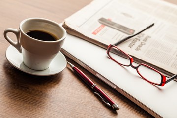 Business Desk with Coffee, Eyeglasses, Laptop and Newspaper