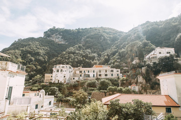 Fototapeta na wymiar The Amalfi coast and the mountain slopes with plantations of lemons. Panoramic view of the city and nature of Italy. Evening landscapes and winding roads