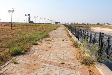 Fototapeta premium abandoned embankment. weeds grow through the tiles